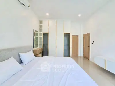 Spacious modern bedroom with minimalist design and ample natural light.