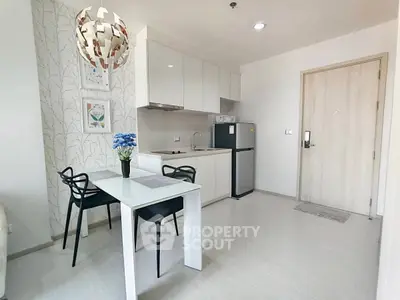 Modern kitchen with sleek white cabinets and dining area in stylish apartment