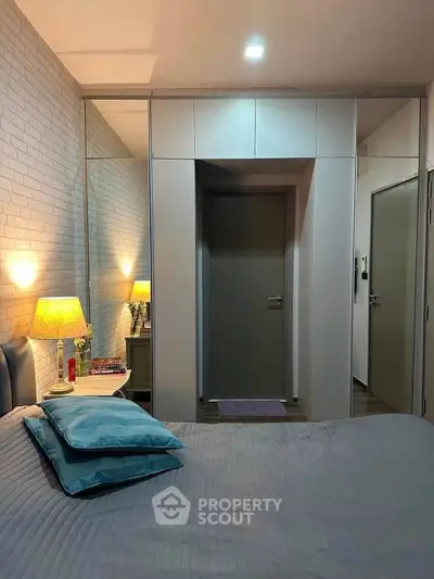 Cozy bedroom with modern decor and soft lighting, featuring a comfortable bed and stylish bedside table.