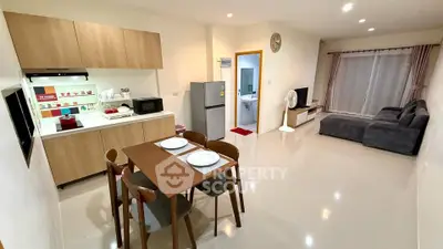 Modern open-plan living room and kitchen with sleek furniture and appliances