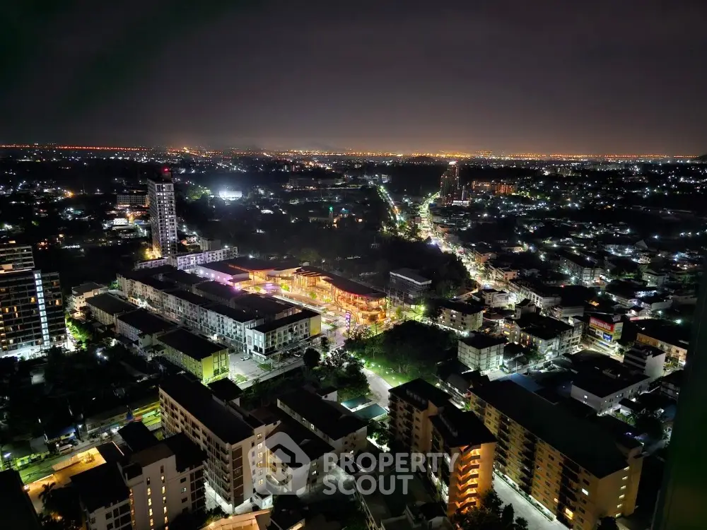 Stunning night cityscape view from high-rise apartment, showcasing vibrant city lights and urban landscape.