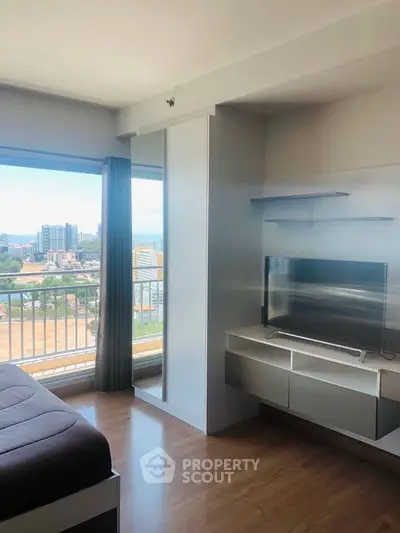 Modern living room with large window and city view, featuring sleek furniture and natural light.