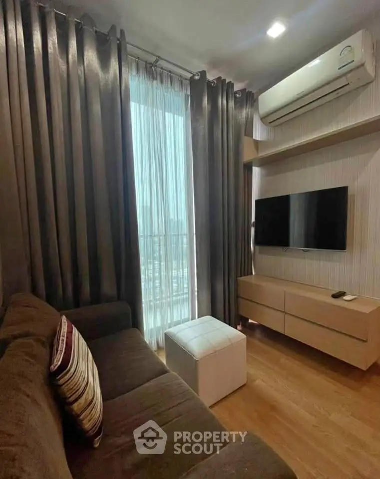 Cozy living room with modern decor, featuring a wall-mounted TV and air conditioning.