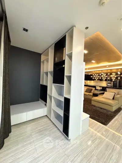 Modern living room with stylish shelving and elegant lighting, featuring a spacious open layout and contemporary design.