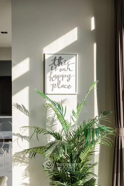 Bright and inviting interior with lush plant and motivational wall art, perfect for a cozy living space.