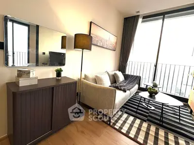 Modern living room with cozy sofa, stylish decor, and large window offering natural light.