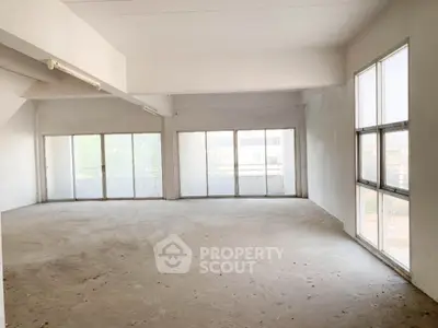 Spacious and bright unfurnished living space with large windows offering ample natural light, perfect for a custom interior design.