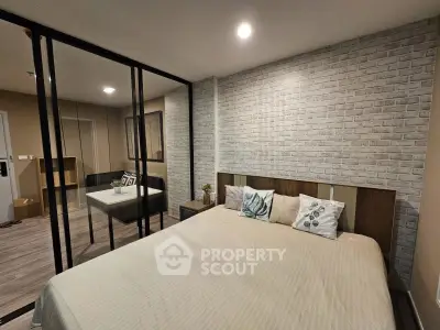 Modern bedroom with stylish brick accent wall and glass partitioned study area.