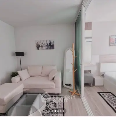 Modern living room with cozy white sofa, glass coffee table, and stylish decor in a bright apartment.