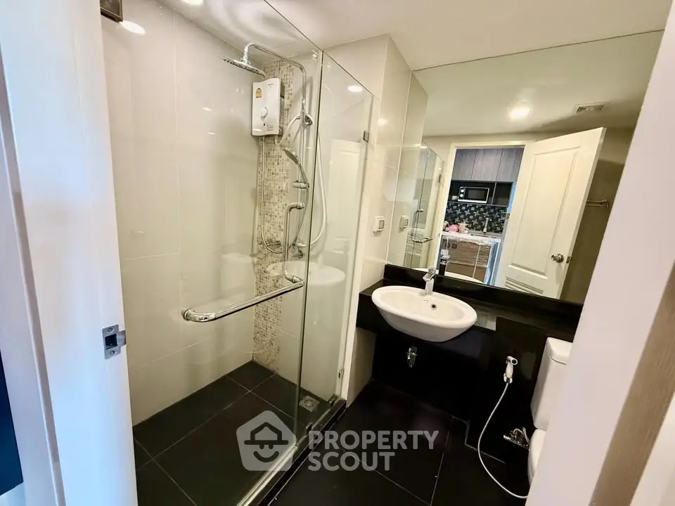 Modern bathroom with glass shower and sleek fixtures in a contemporary apartment.