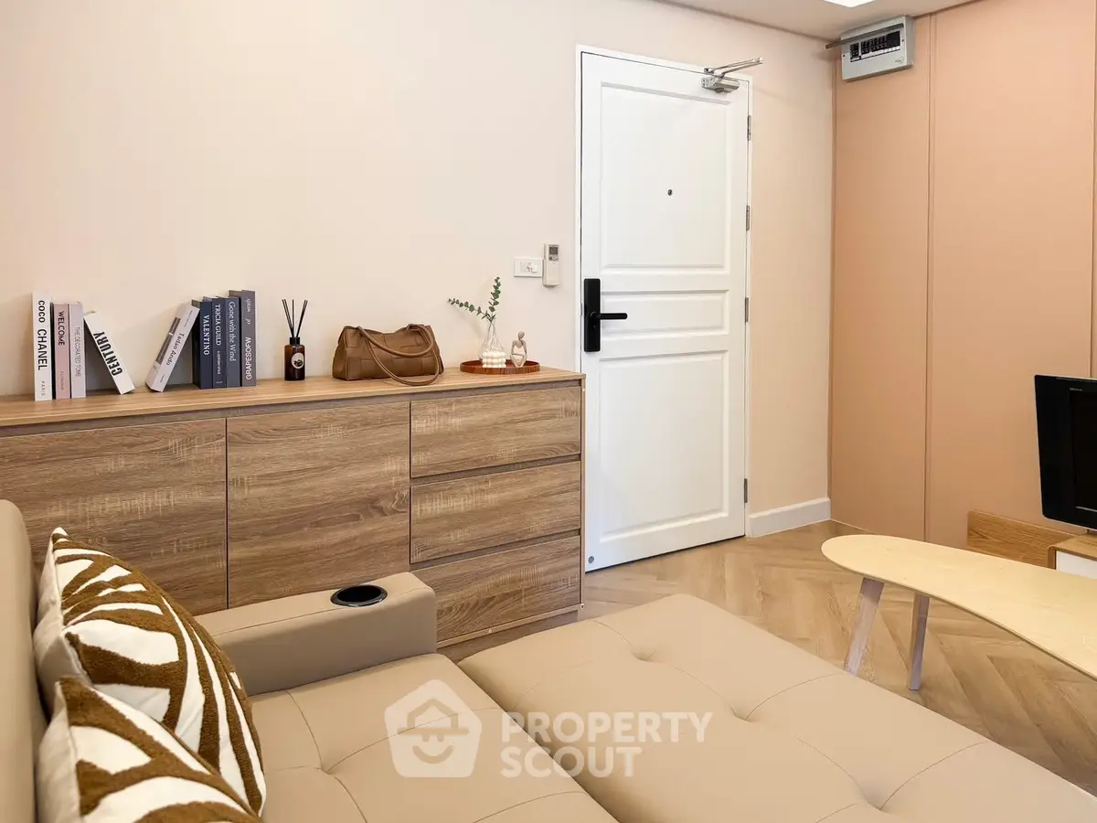 Modern living room with stylish decor and neutral tones, featuring a cozy sofa and wooden accents.