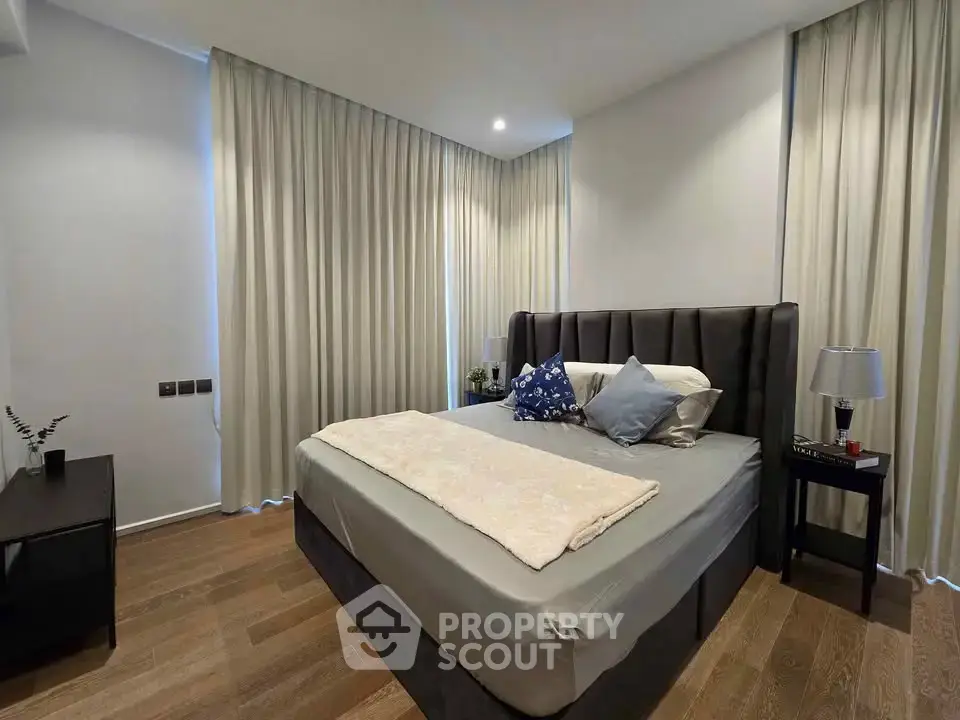 Modern bedroom with elegant decor and cozy ambiance, featuring a plush bed and stylish furnishings.
