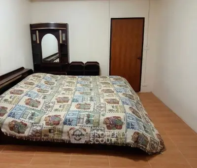 Cozy bedroom with patterned bedding and wooden flooring