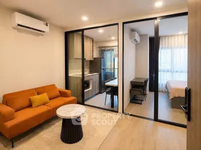 Modern apartment interior with open living room and kitchen, featuring stylish furniture and natural light.