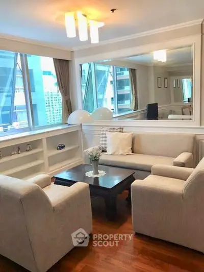 Elegant living room with large windows and modern furniture in a high-rise apartment.