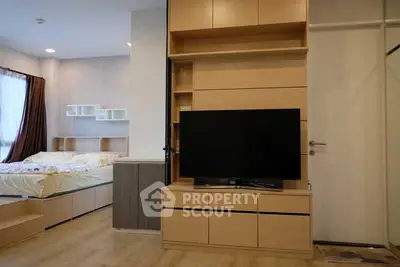 Modern bedroom with built-in TV unit and cozy bed setup