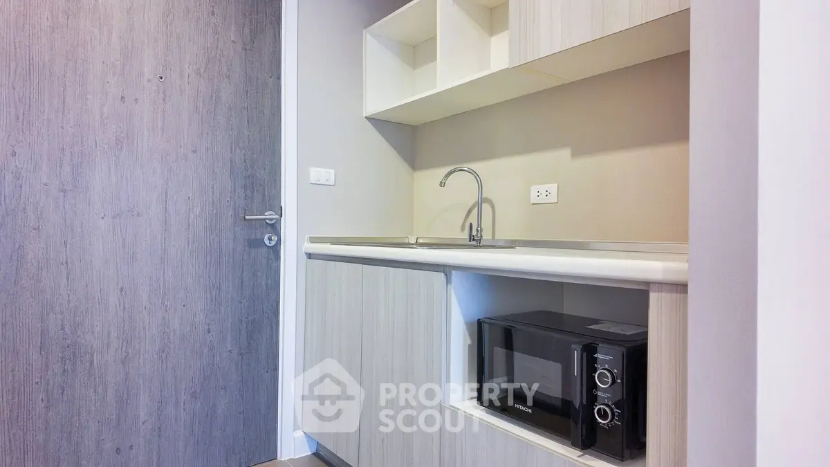 Modern compact kitchen with microwave and sleek cabinetry