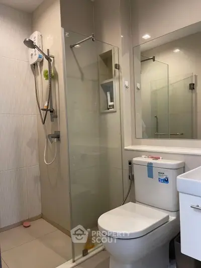 Modern bathroom with glass shower enclosure and sleek fixtures.