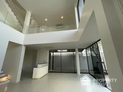 Spacious modern interior with high ceilings and large windows in a contemporary home.