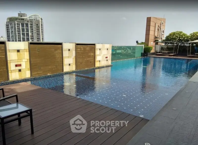 Luxurious rooftop pool with city skyline view and modern deck area.