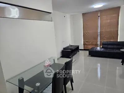 Modern living room with sleek black furniture and glass dining table, perfect for urban living.