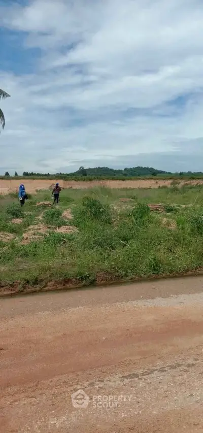 Expansive land plot with lush greenery and distant hills, perfect for development opportunities.