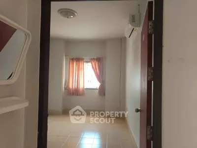 Cozy unfurnished room with tiled floor and air conditioning, perfect for customization.