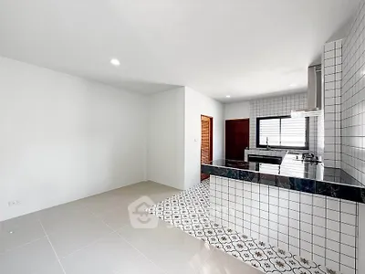Modern kitchen with sleek black countertops and stylish tile flooring in a bright, open layout.