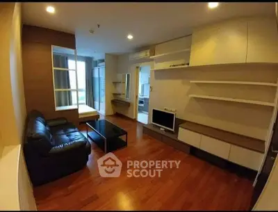 Spacious living room with modern furnishings and hardwood floors in a stylish apartment.