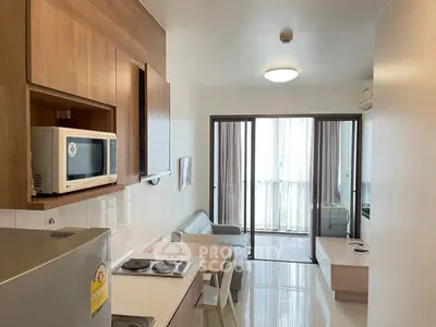 Modern open-layout kitchen and living room with sleek furniture and natural light.