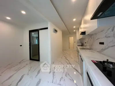 Modern kitchen with sleek marble flooring and built-in gas stove in a contemporary apartment.