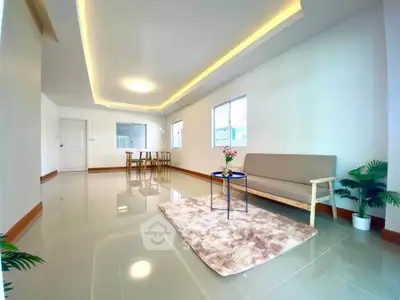 Spacious modern living room with sleek flooring and cozy seating area.