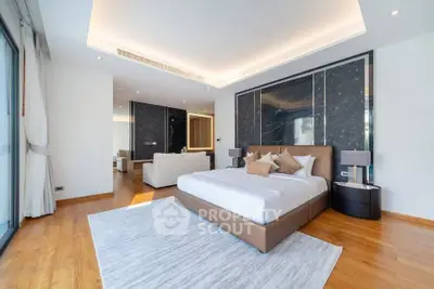 Luxurious modern bedroom with elegant decor and spacious layout, featuring a stylish bed and hardwood flooring.