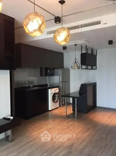 Modern kitchen with sleek black cabinets and integrated appliances in open layout.