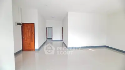 Spacious and bright interior with sleek tile flooring and wooden doors, perfect for modern living.