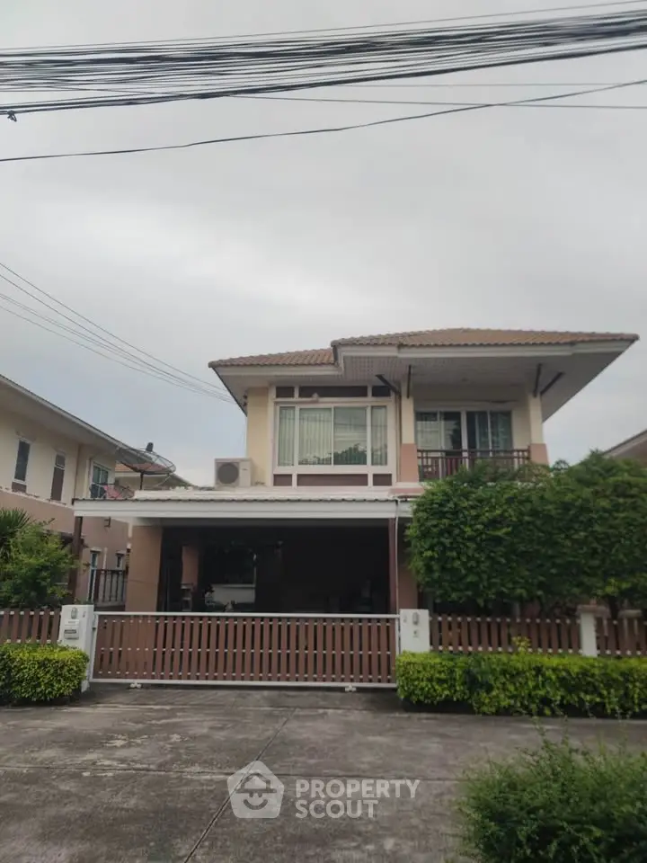 Charming two-story house with lush greenery and modern design in a serene neighborhood.