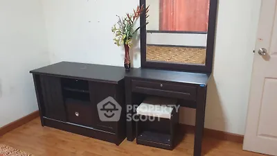 Elegant bedroom setup with dark wood furniture and decorative mirror