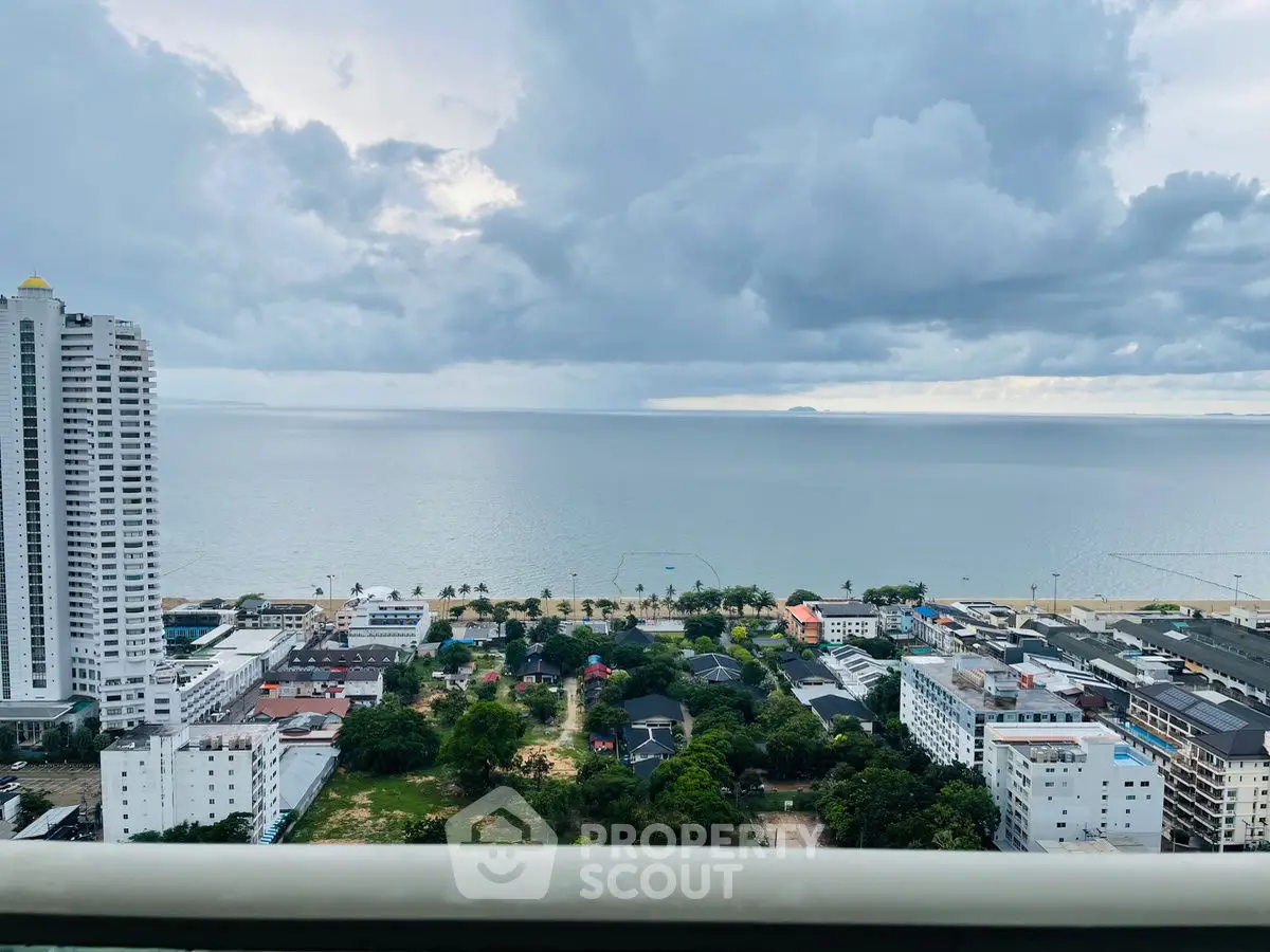 Stunning ocean view from high-rise balcony overlooking cityscape and beach.
