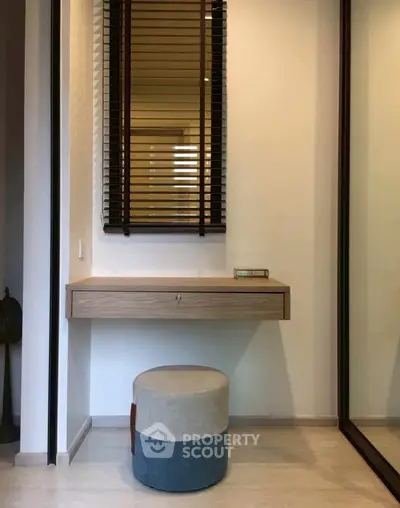 Modern minimalist study nook with floating desk and stylish stool in a contemporary apartment.