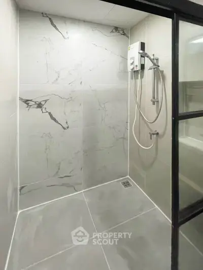 Modern bathroom with sleek marble tiles and glass shower enclosure