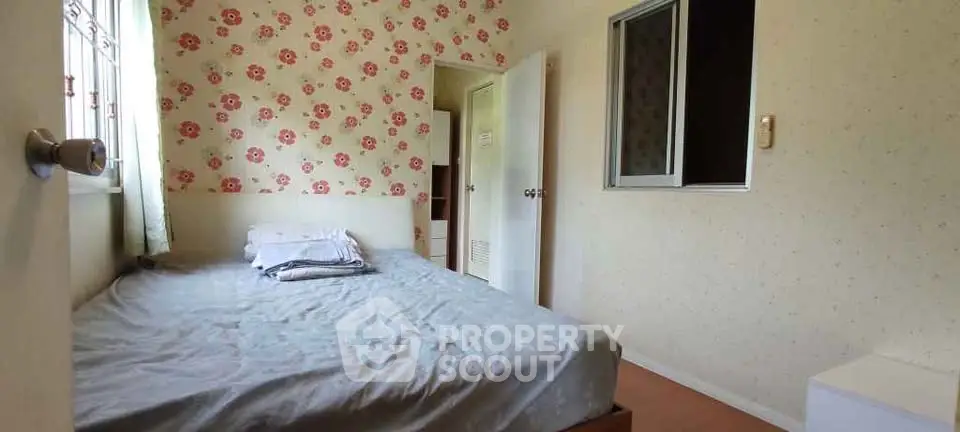 Cozy bedroom with floral wallpaper and natural light