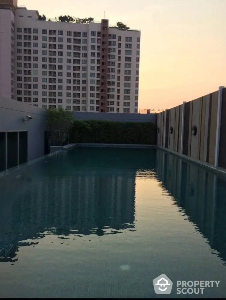 Stunning rooftop pool with cityscape view at sunset, perfect for relaxation and leisure.