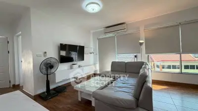Modern living room with sleek furniture and large windows offering natural light.