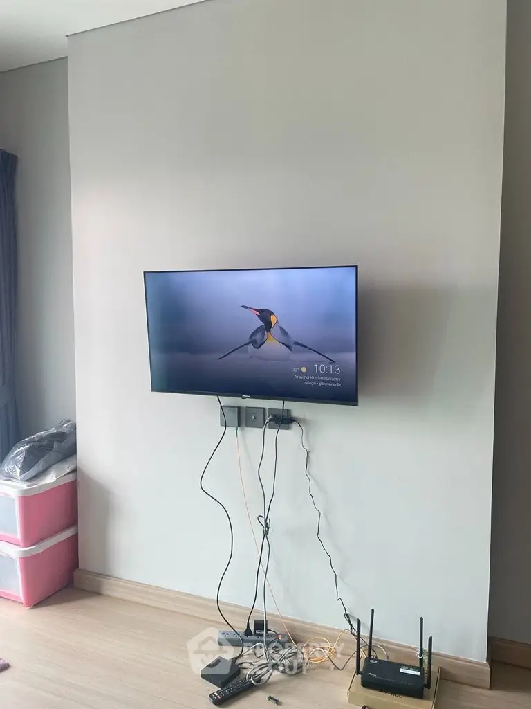 Modern living room with wall-mounted TV and sleek wooden flooring
