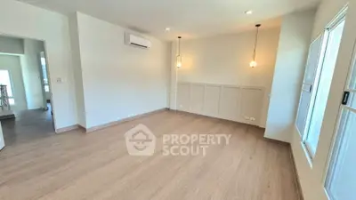 Spacious empty room with wooden flooring and modern lighting, ideal for customization.