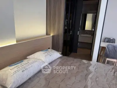 Modern bedroom with stylish decor and cozy lighting, featuring a comfortable bed and sleek furnishings.