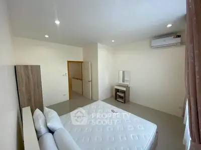 Spacious bedroom with modern furnishings and air conditioning in a bright, minimalist style.