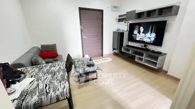 Modern living room with stylish furniture and large TV, perfect for relaxation.