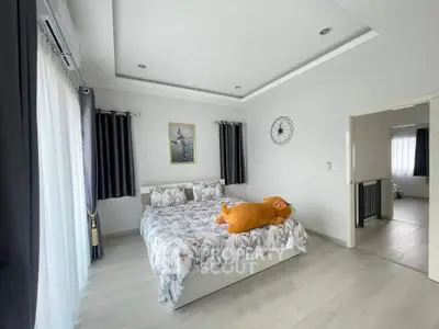 Spacious bedroom with modern decor and large windows for natural light.