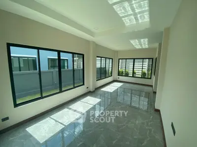 Spacious sunlit room with large windows and glossy marble flooring